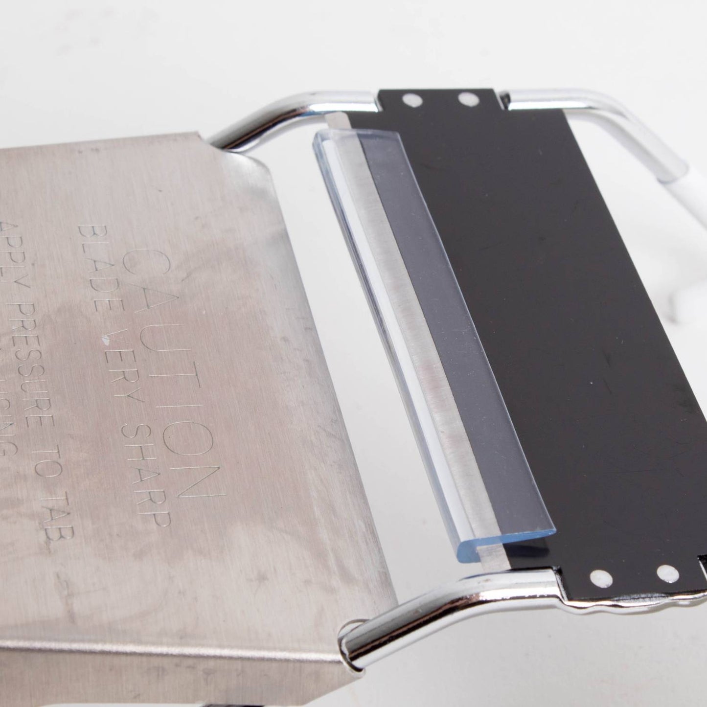 Close-up of stainless steel mandoline slicer blade with black safety guard for kitchenware under $50 collection