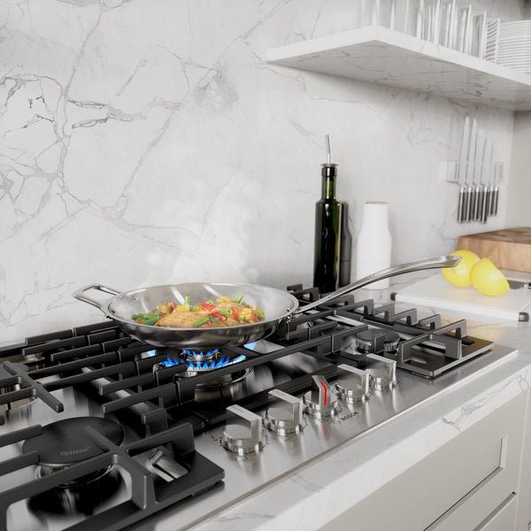 Black gas cooktop with five burners, stainless steel knobs, and cast iron grates in modern kitchen setting