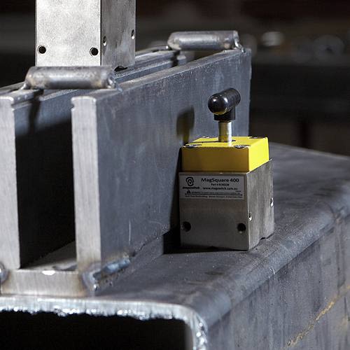 Yellow and steel magnetic workholding fixture securing metal pieces for power tool accessories and home improvement tasks