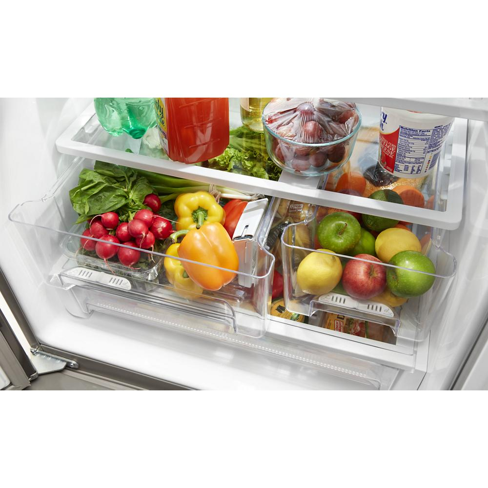 Fresh produce including radishes, bell peppers, apples, and lemons stored in humidity-controlled crisper drawers inside refrigerator interior