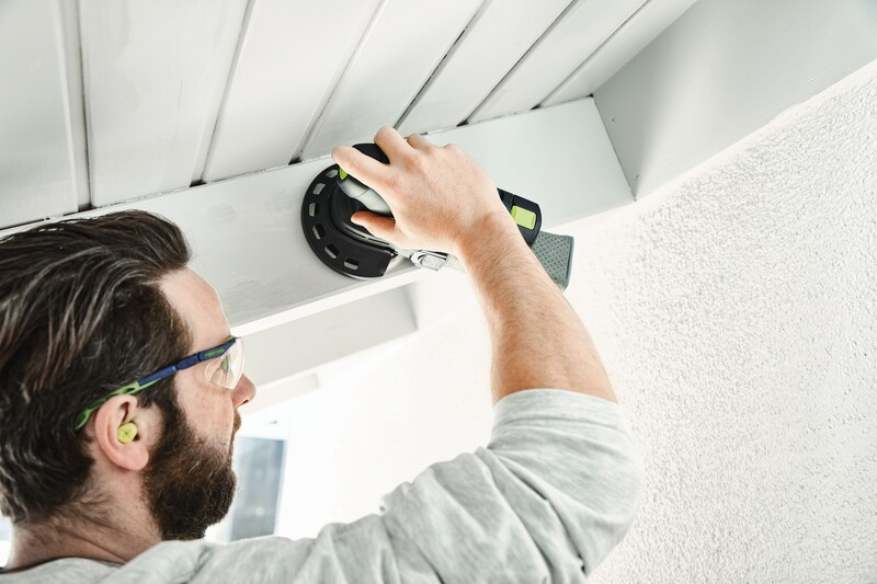 Man using handheld sander with edge protector on ceiling trim in woodworking tool accessories collection under $50