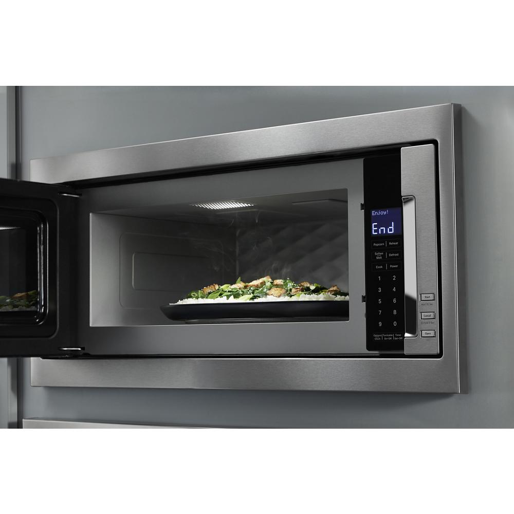 Built-in stainless steel microwave with digital control panel open showing plate of food inside kitchen appliances collection