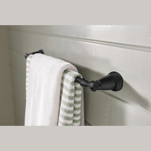 Matte black towel bar with classic design holding white and striped green towels on a painted wood wall for home improvement