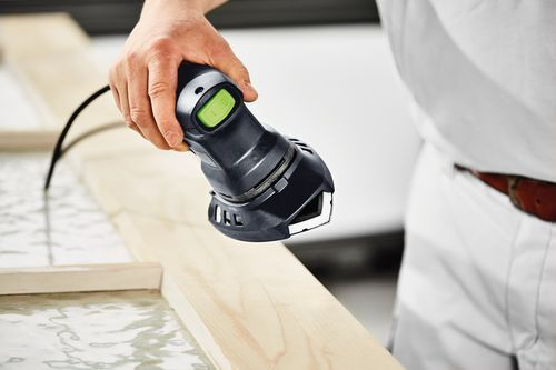 Handheld finish delta sander smoothing wooden frame edge in home improvement and woodworking project setting
