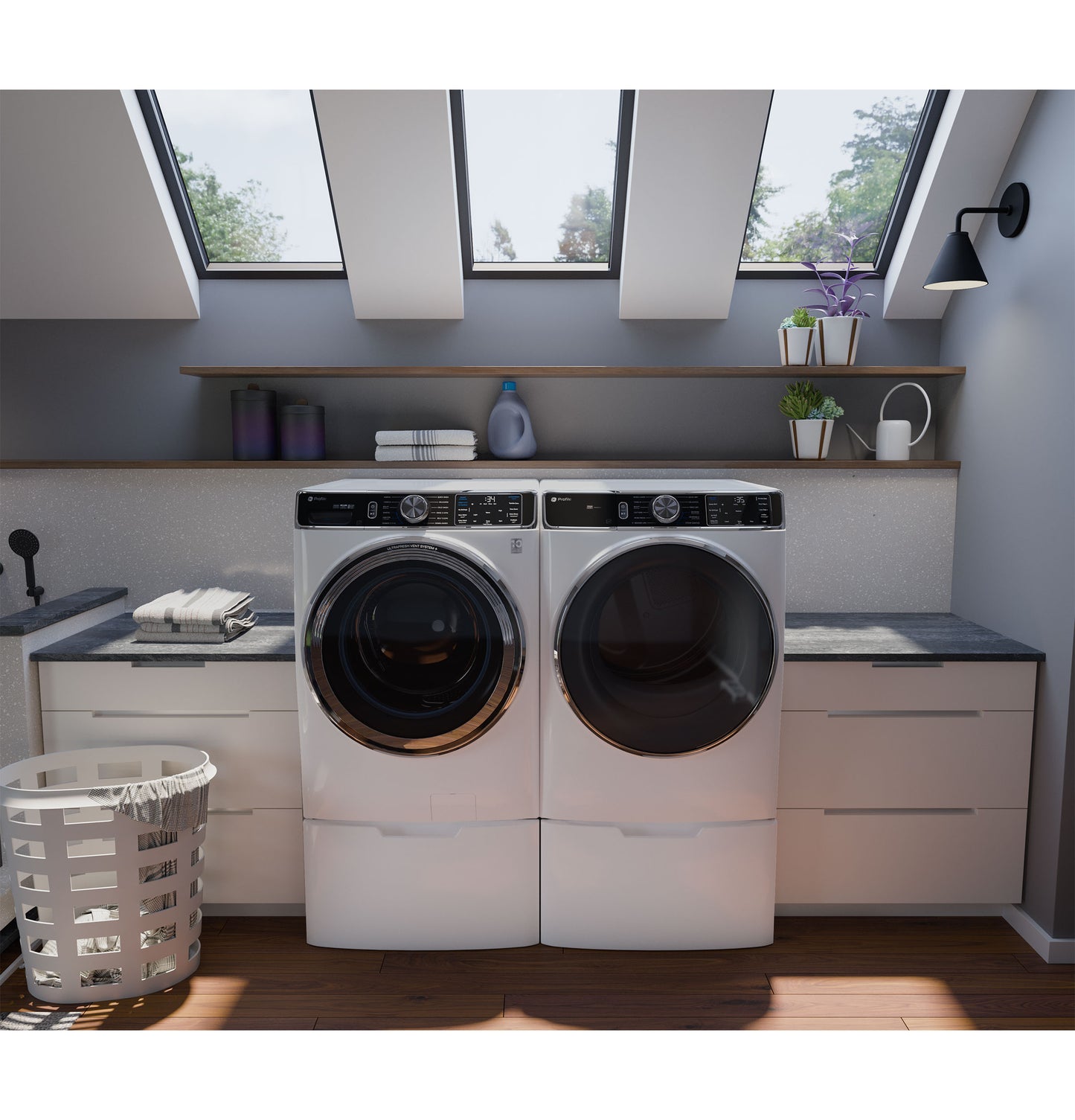 Modern laundry room with white front load washer and dryer set under natural skylight and gray walls