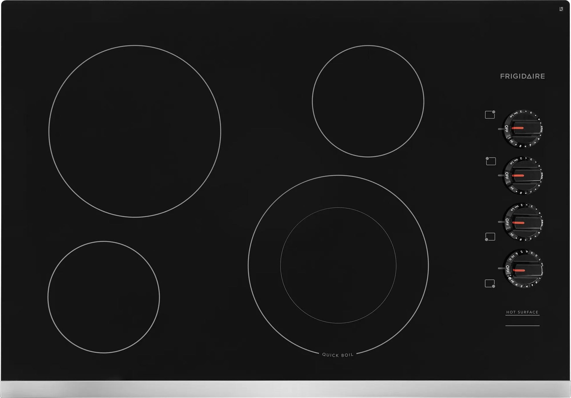 Black electric cooktop with four heating elements and control knobs on the right side in kitchenware setting
