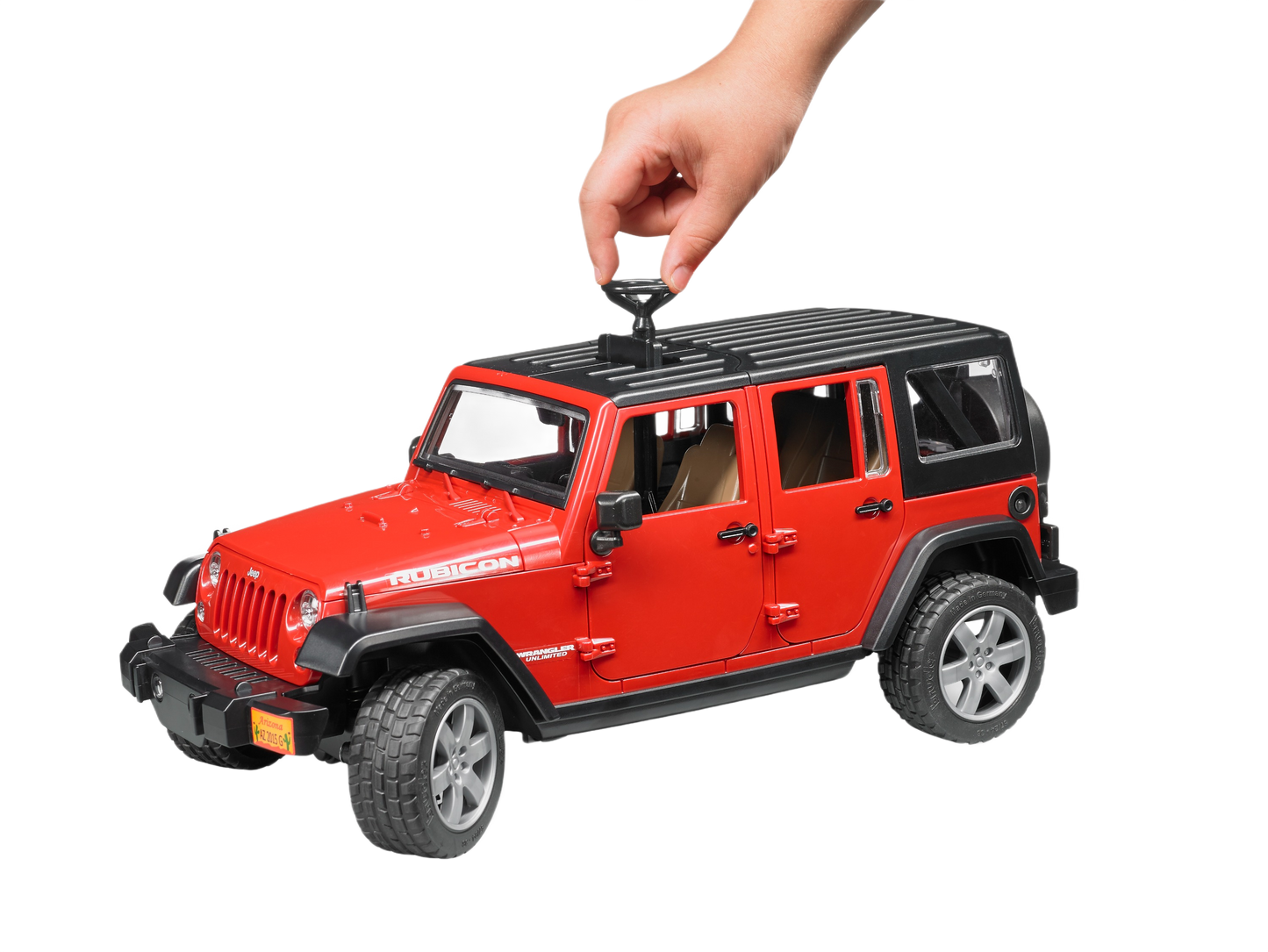 Hand placing a removable roof piece on a red Bruder Toys Jeep Wrangler model from Vehicles & Remote Controlled Toys collection