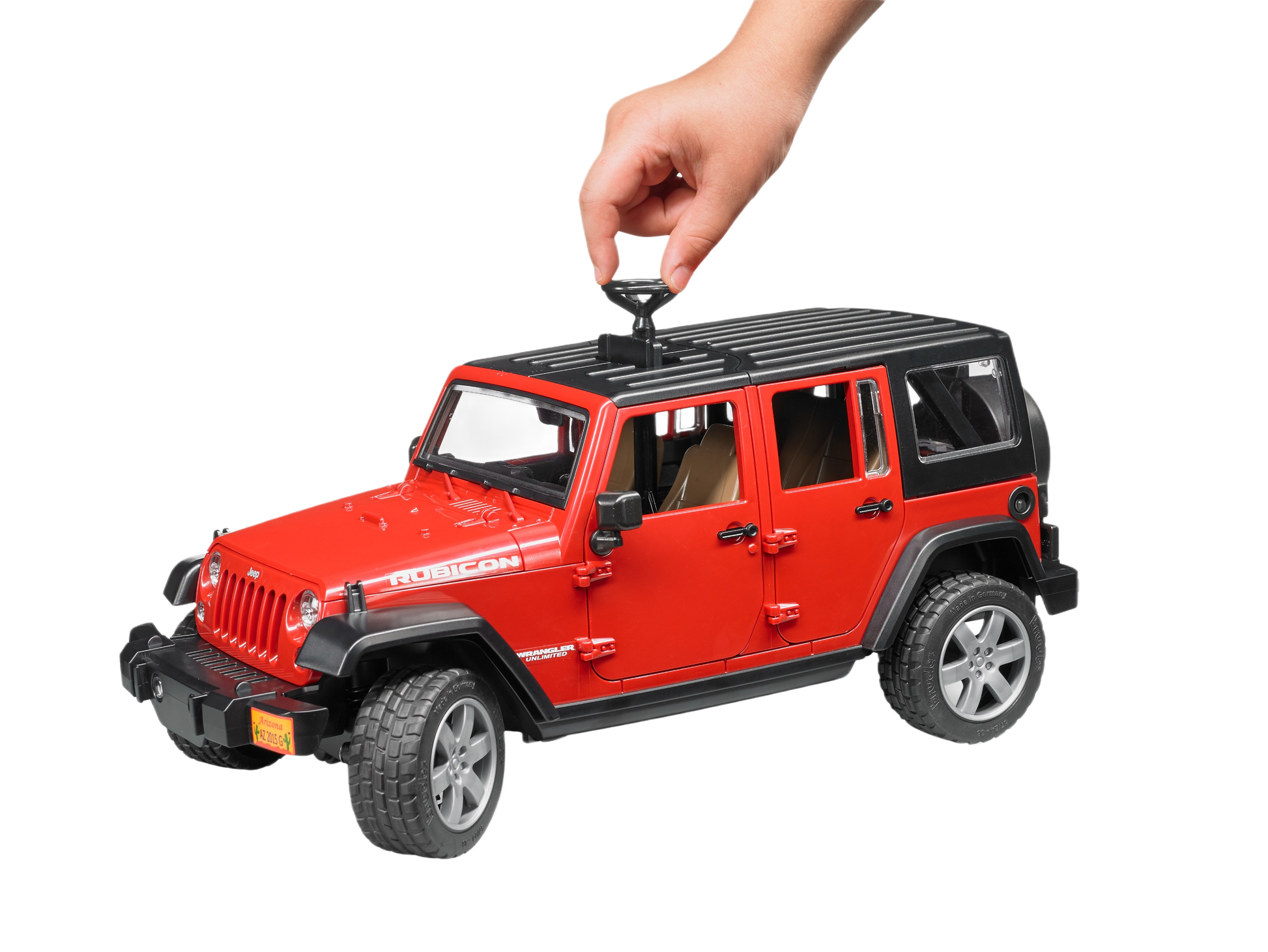 Hand placing a removable roof piece on a red Bruder Toys Jeep Wrangler model from Vehicles & Remote Controlled Toys collection