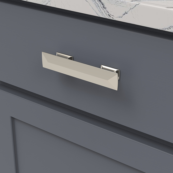 Rectangular polished nickel cabinet pull with beveled edges on dark blue cabinetry in home improvement setting