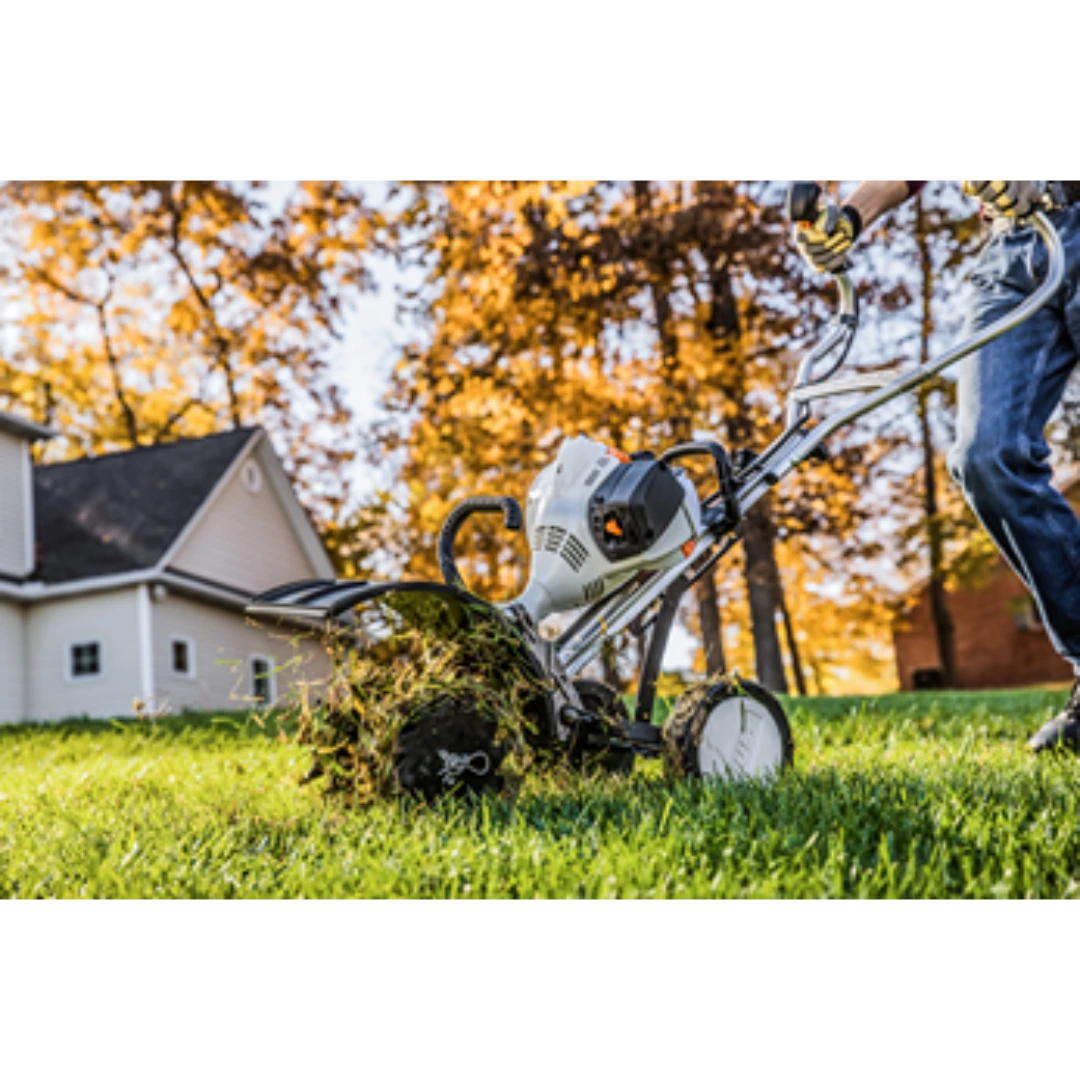 Gas-powered garden tiller with wheel kit breaking up soil on green lawn for home improvement tasks