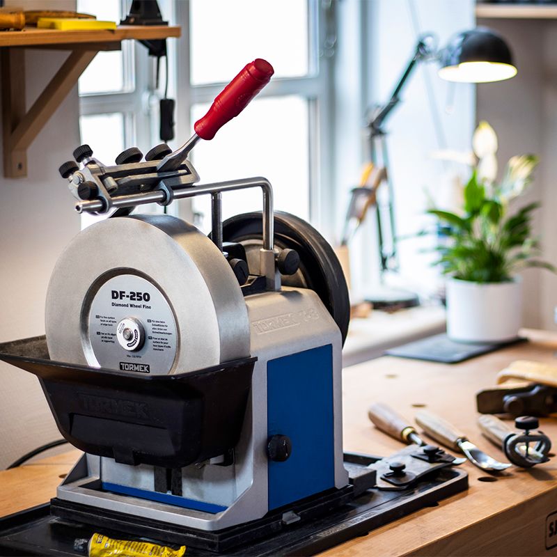 Bench-mounted sharpening system with diamond grinding wheel and adjustable tool rest in woodworking tool accessories collection