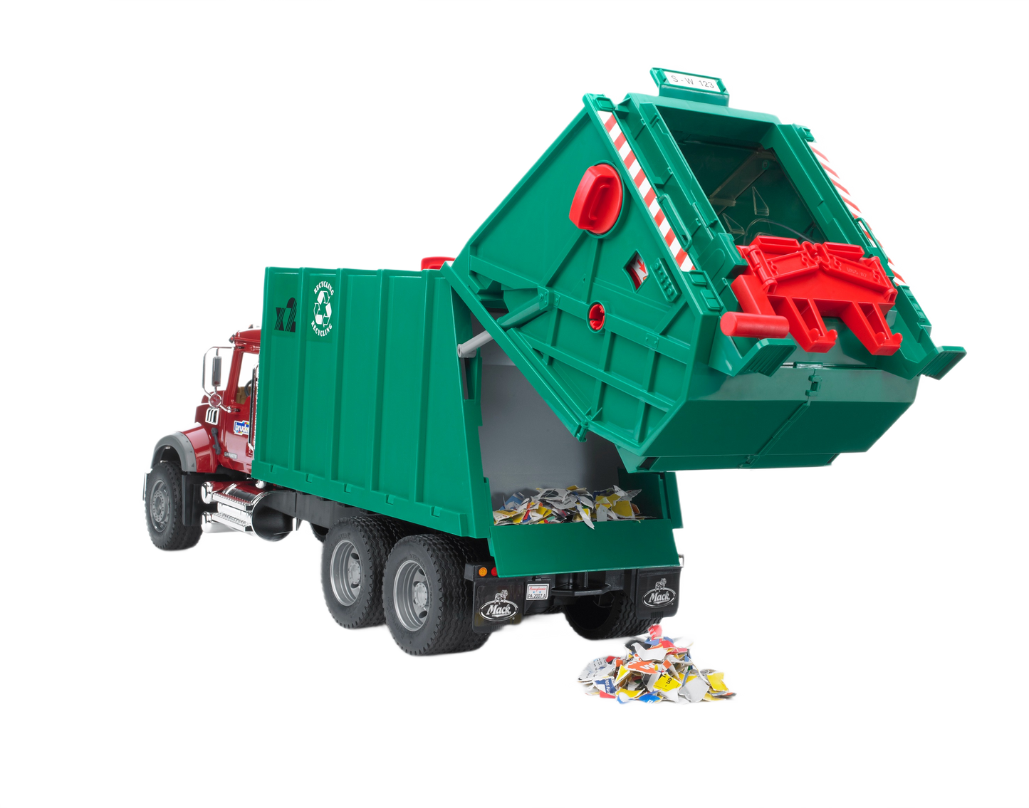 Red and green scale model Mack Granite garbage truck with tipping rear container and scattered toy trash in Bruder Toys collection