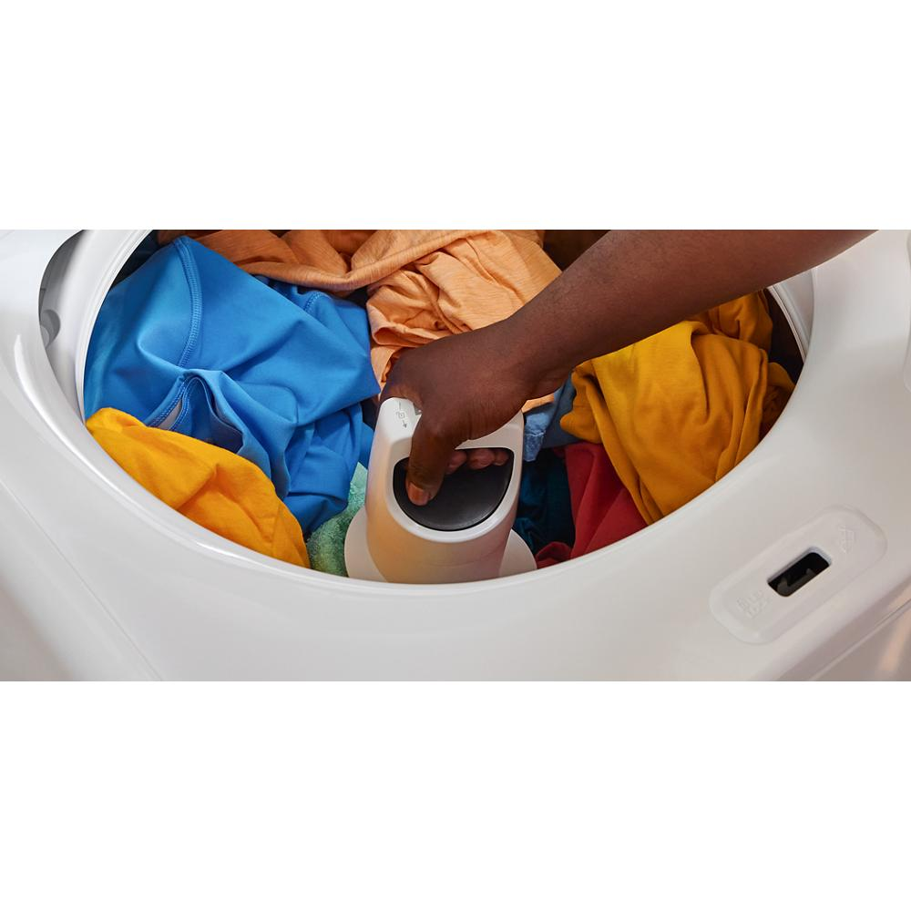 Hand using 2-in-1 removable agitator inside a white top load washer with colorful clothes in appliance collection