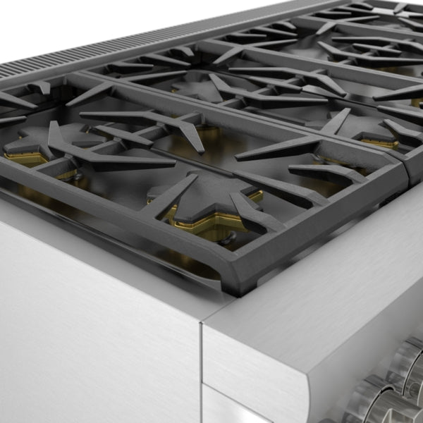 Close-up of stainless steel commercial depth dual fuel range cooktop with black cast iron grates and brass burners from Ranges collection