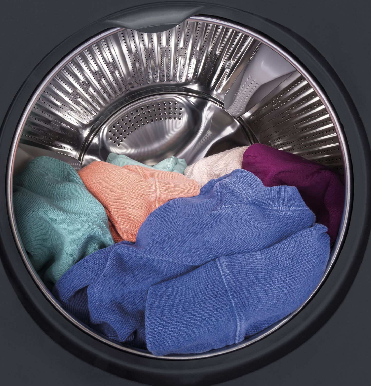Front load washer drum filled with colorful clothing ready for washing in Washers & Dryers collection