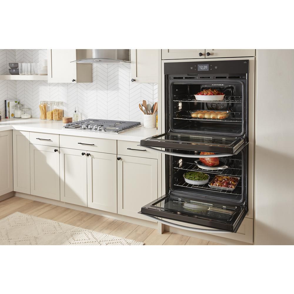 Modern kitchen featuring a built-in double smart wall oven with two racks of cooking dishes, part of wall ovens collection