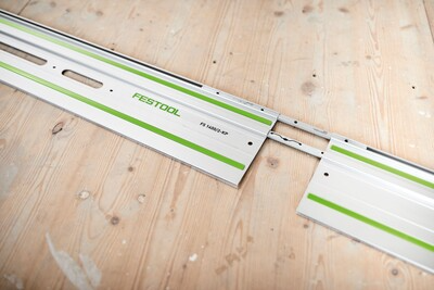 Two metallic Festool guide rail connectors joining saw tracks for woodworking tool accessories in home improvement.