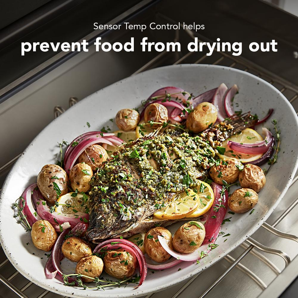 Roasted whole fish with herbs, lemon slices, baby potatoes, and red onions in warming drawer oven setting