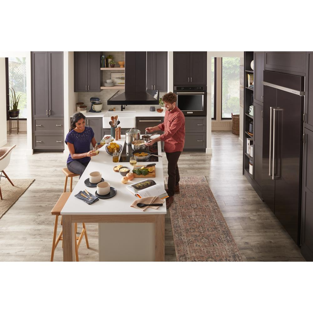Contemporary kitchen with dark cabinetry, large island, 36-inch island-mount canopy hood, and stainless steel appliances from KitchenAid collection