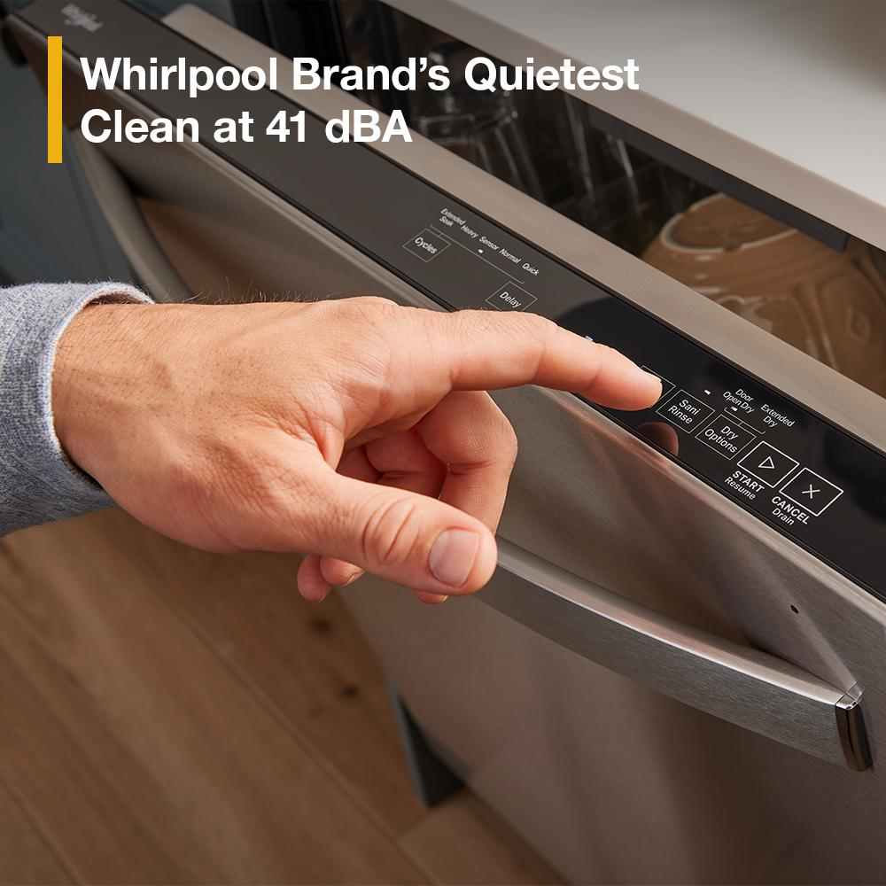 Hand pressing control panel buttons on a stainless steel dishwasher in a modern kitchen setting