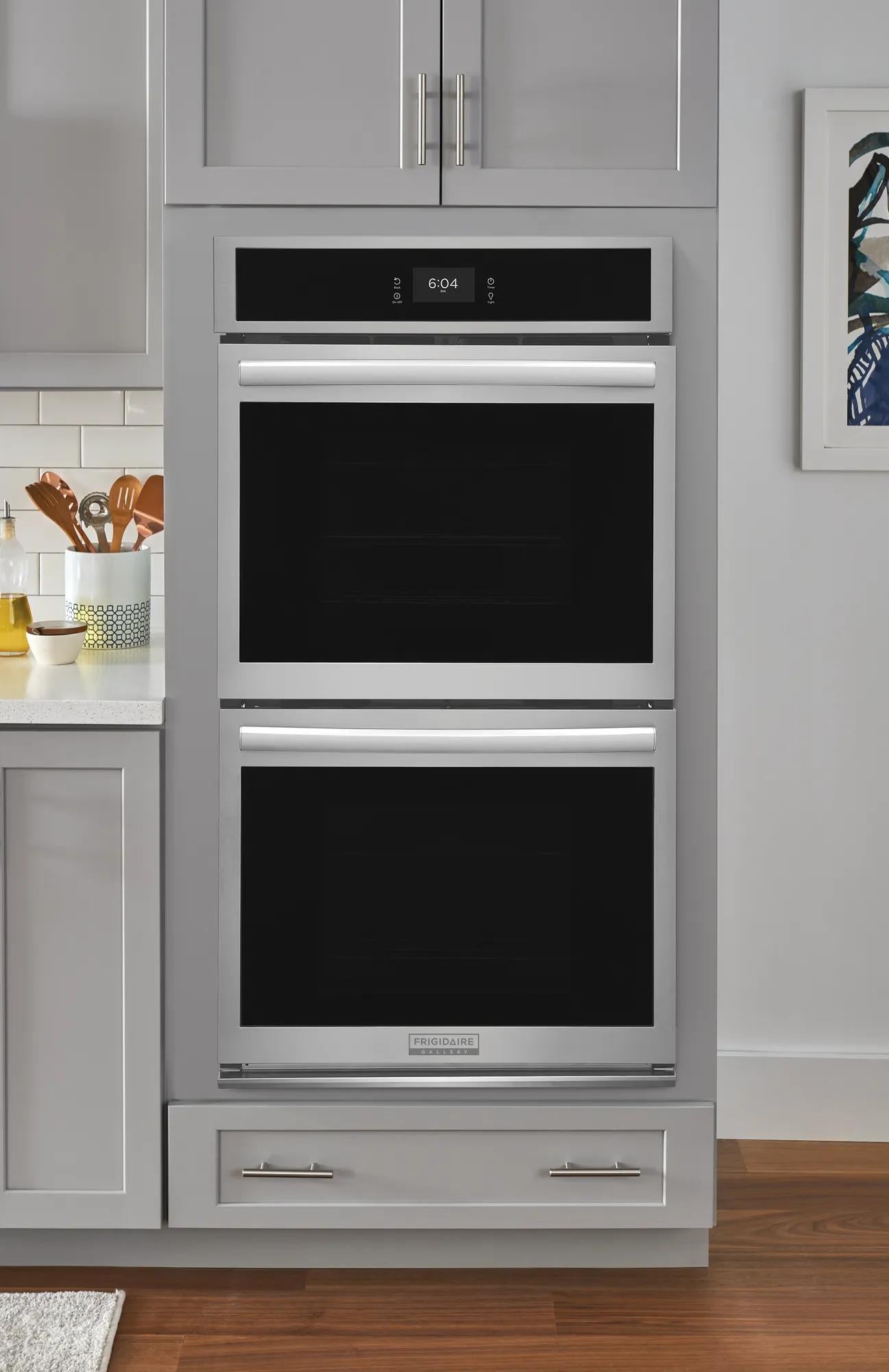 Stainless steel double wall oven with total convection system built into gray cabinetry in modern kitchen setting