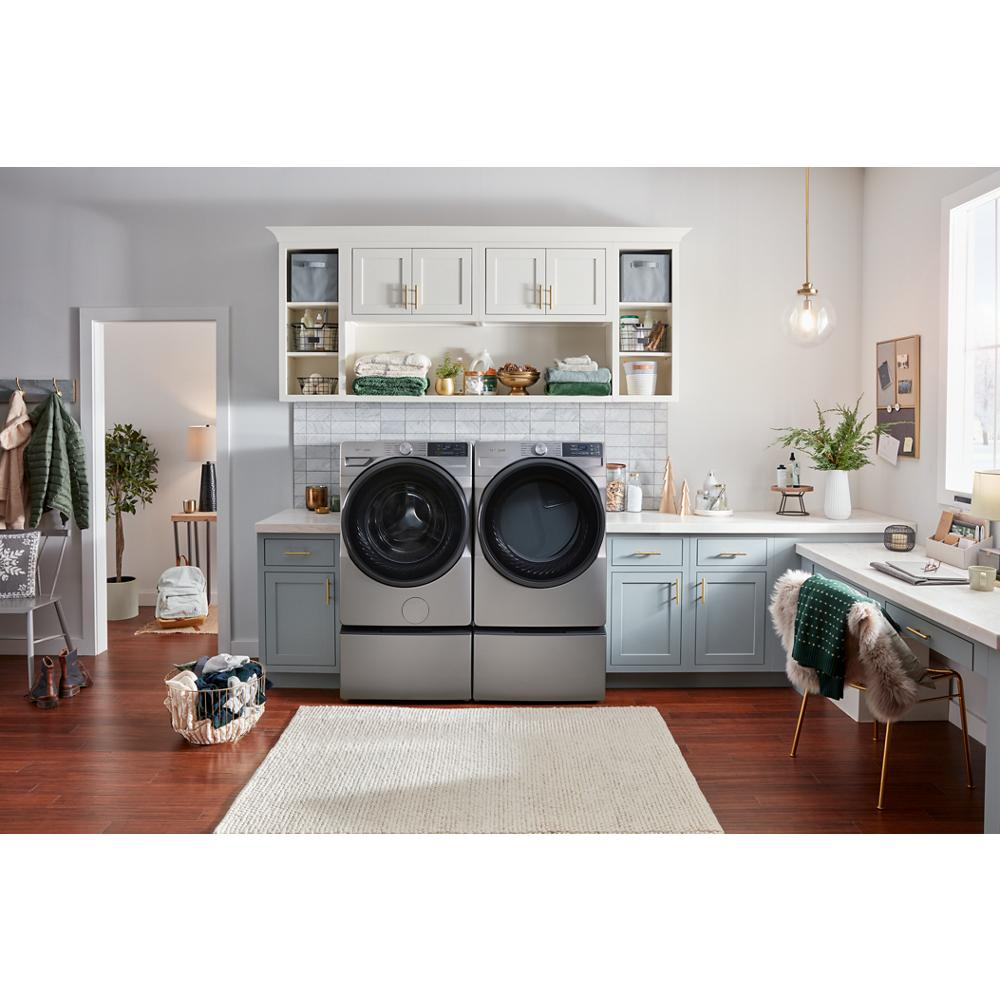 Modern laundry room featuring smart front load electric dryer and washer in gray surrounded by blue and white cabinetry