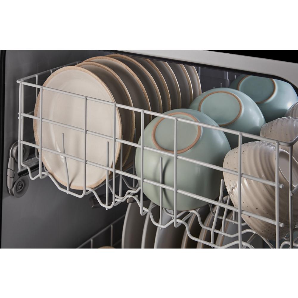 Open dishwasher rack loaded with ceramic plates and bowls in a kitchen appliance from the dishwashers collection