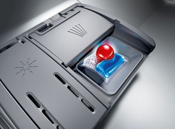 Close-up of dishwasher detergent compartment with a colorful detergent pod inside from kitchen appliances collection
