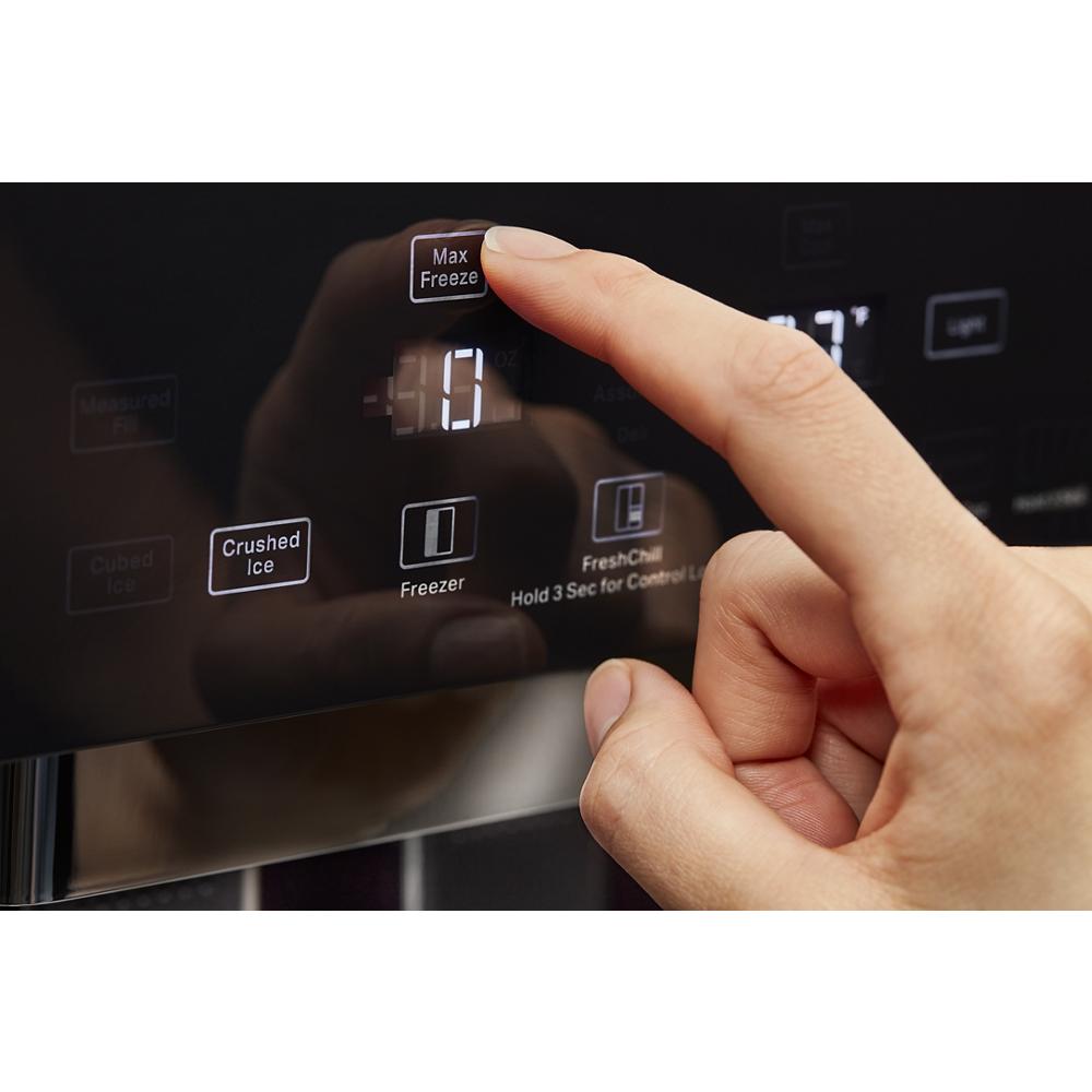 Finger pressing Max Freeze button on black control panel of built-in side-by-side refrigerator from KitchenAid Appliances collection