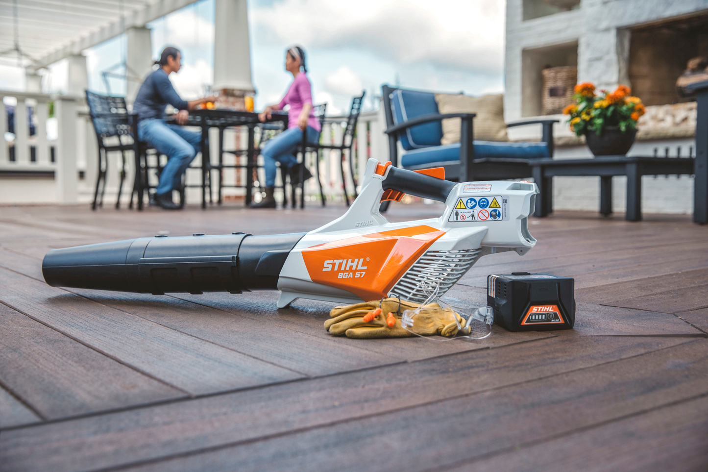 Orange and white battery-powered handheld blower with protective gloves and battery pack for outdoor tools and home improvement tasks