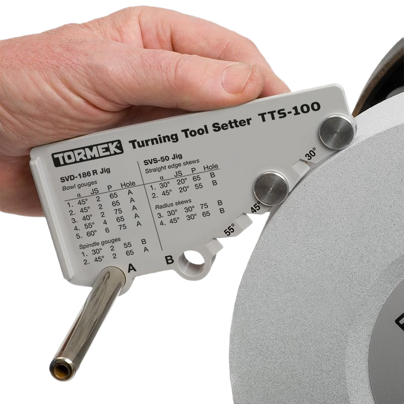 Hand holding Tormek TTS-100 turning tool setter with engraved angle guides for precise woodturning tool sharpening