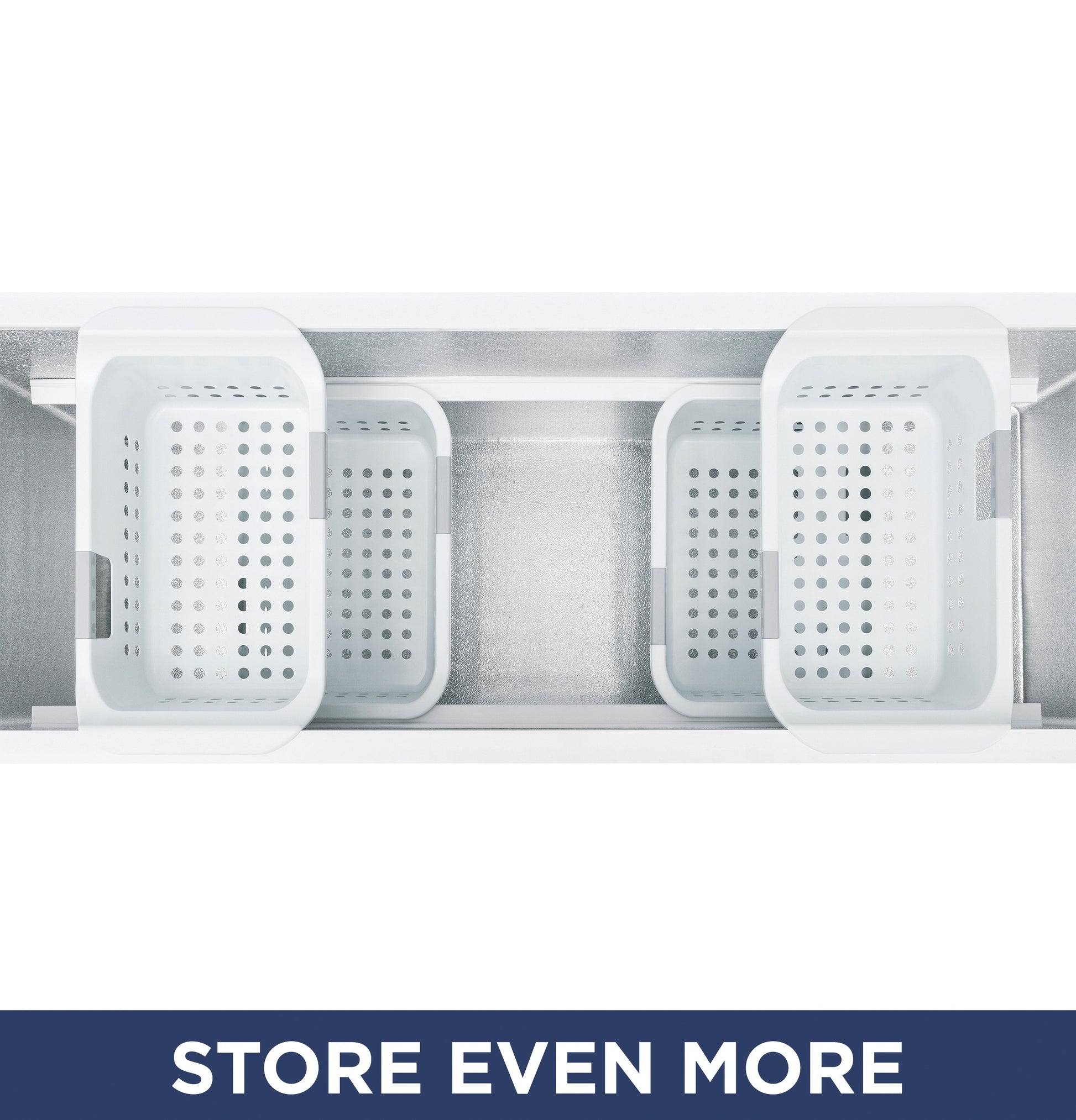 Top view inside manual defrost chest freezer showing four removable white storage baskets for organization.