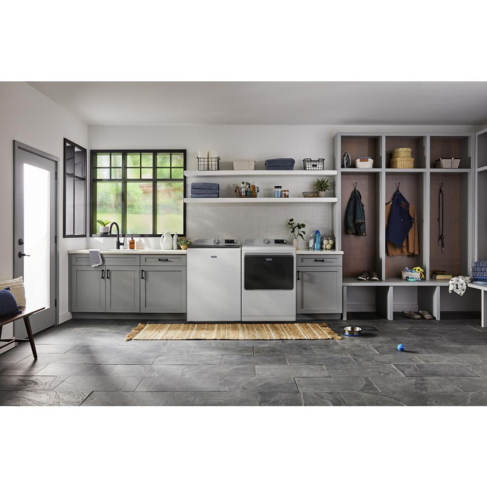 Laundry room with modern gray cabinets, a washer and dryer set, open shelving, and a built-in bench with storage cubbies in a home improvement setting