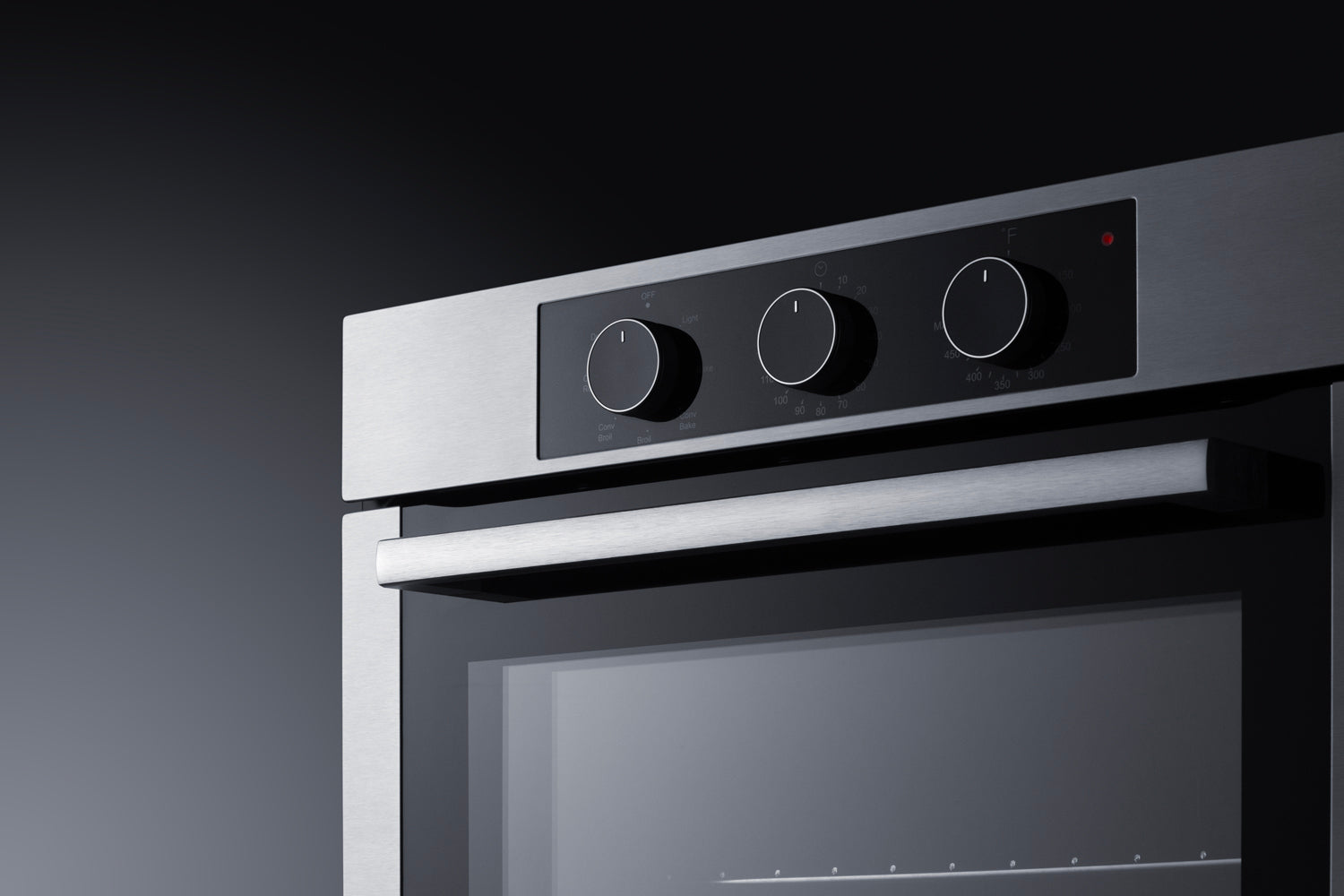 Close-up of stainless steel electric wall oven control panel with three knobs and sleek handle from Kitchen & Kitchenware collection