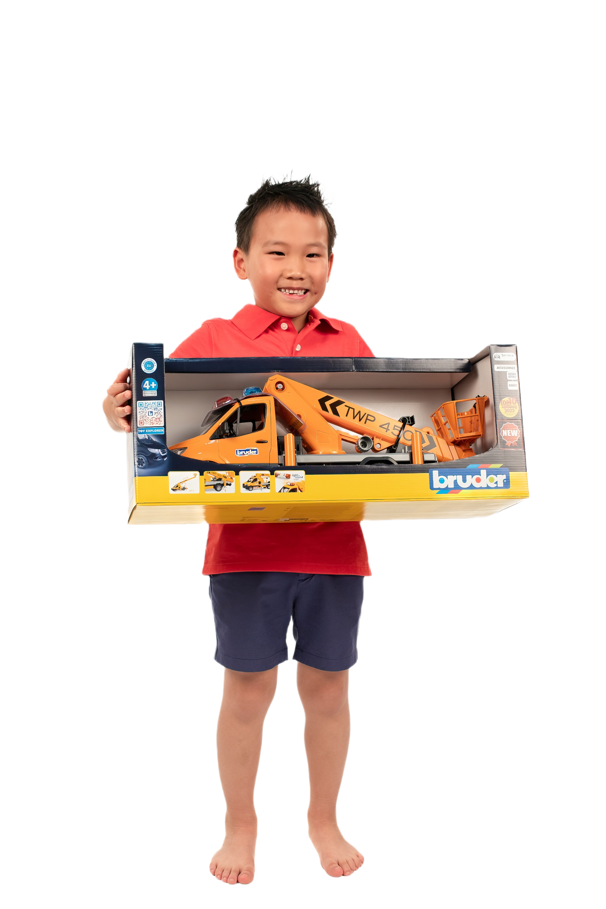 Child holding boxed orange toy truck with working platform and lifting module for home improvement play