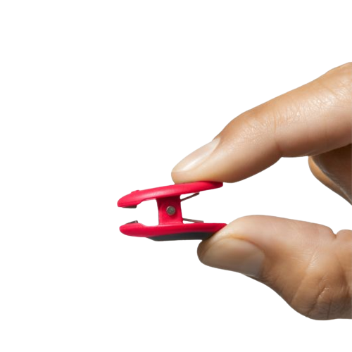 Hand holding a small red magnetic clip designed for organizing and securing items in home improvement tasks