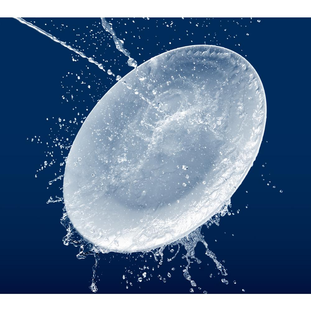 Close-up of water droplets splashing against a clean white dish representing dishwasher cleaning power in kitchenware collection