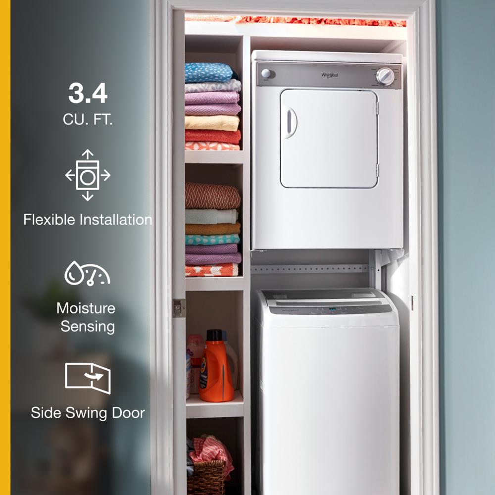 Compact white front load dryer with side swing door stacked above washer in closet with colorful folded towels and detergent