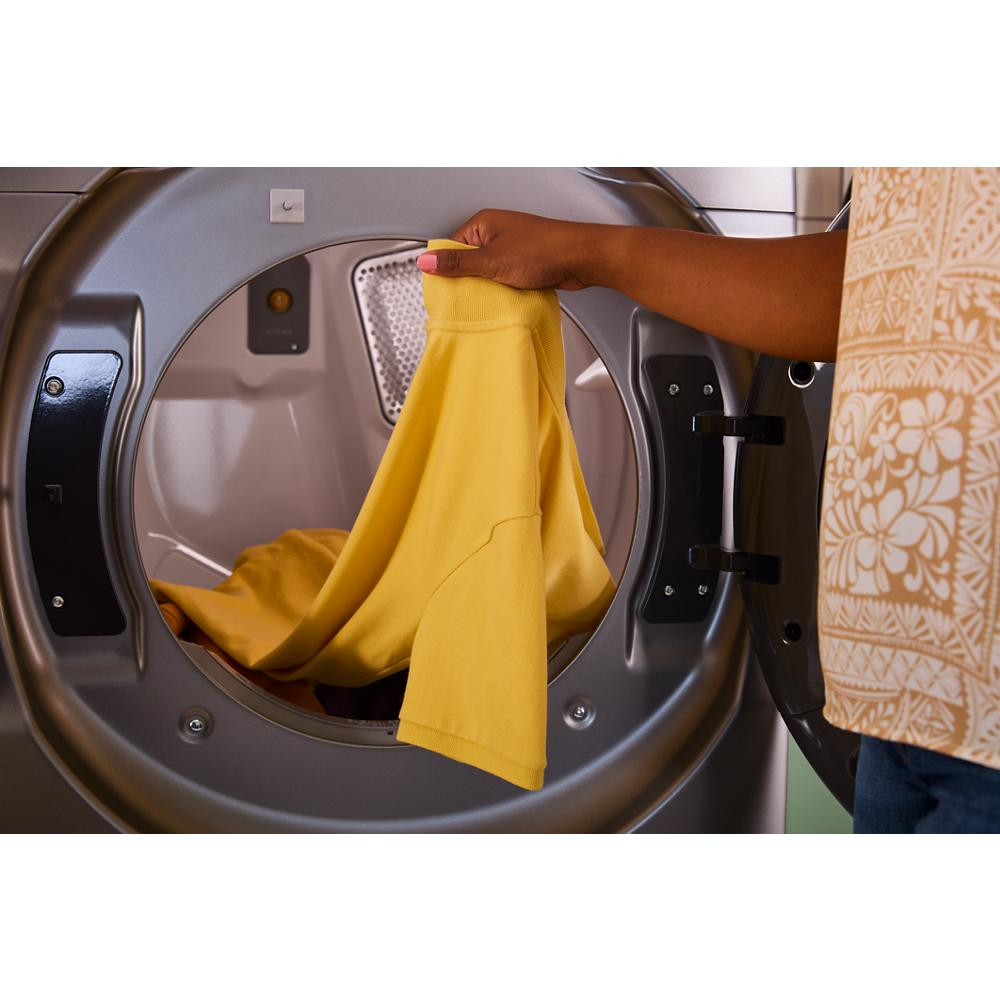 Person removing yellow garment from front load gas dryer drum in laundry room setting from Dryers collection