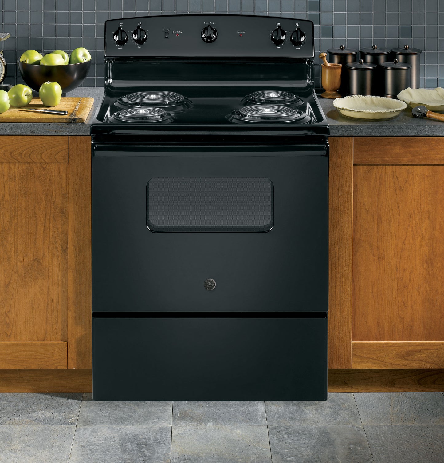 Black free-standing electric range with four coil burners, oven window, and control knobs in a kitchen setting