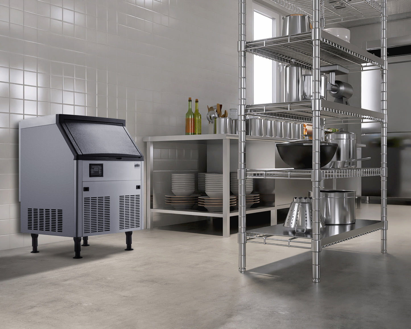 Stainless steel commercial ice machine in modern kitchen with metal shelving and stainless cookware nearby