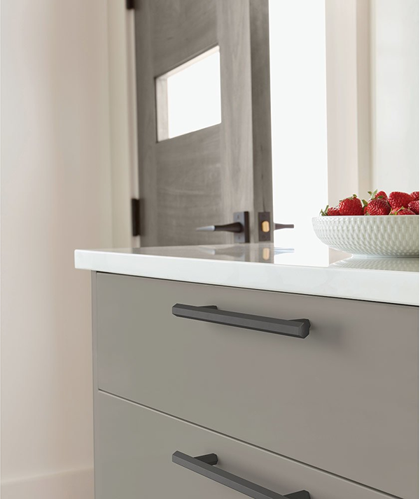 Matte black geometric cabinet pull on light gray drawer in modern kitchen for hardware and furniture accessories under $50 collections