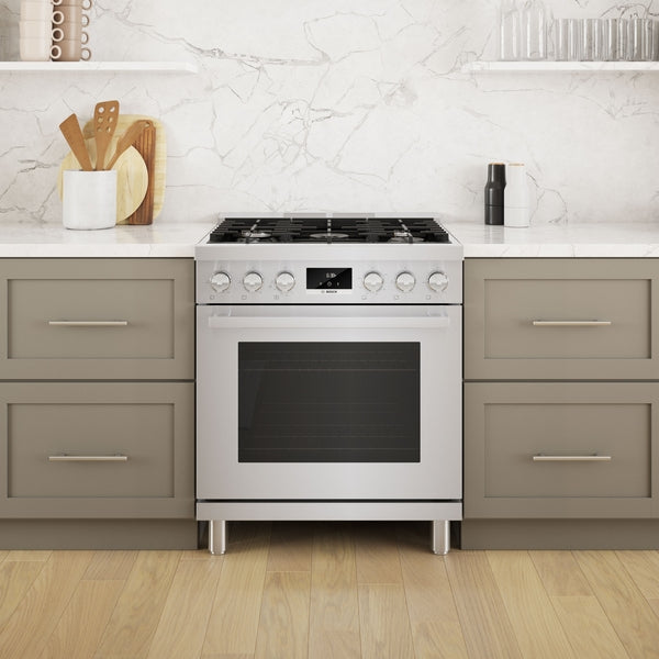 Freestanding 30-inch stainless steel gas range with digital display and metal knobs in modern kitchen setup
