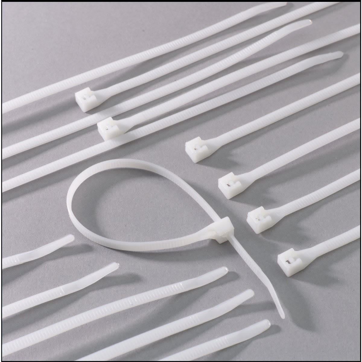 Set of white nylon cable ties with double-lock teeth design for secure bundling in electrical and home improvement projects under $50
