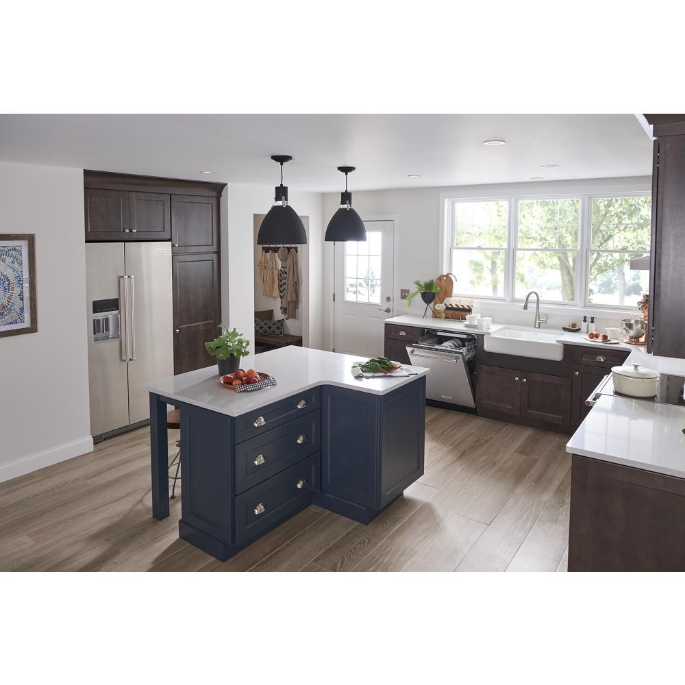 bright kitchen with dark wood cabinets, blue island, farmhouse sink, and stainless steel appliances in KitchenAid collection