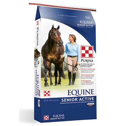 Blue and white 50 lb. bag of Purina Equine Senior Active horse feed with a woman walking beside a brown horse