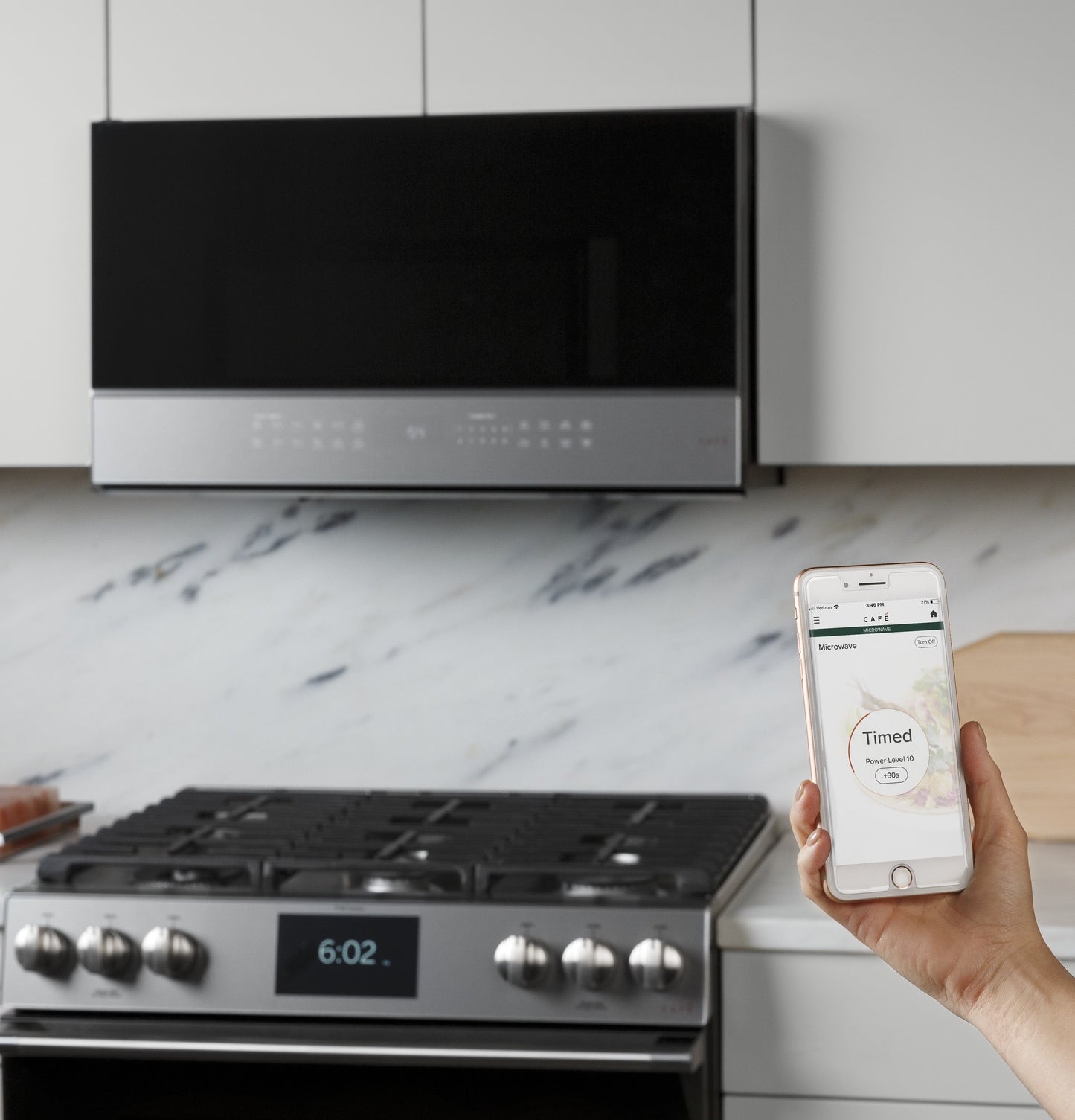 Smart over-the-range microwave with platinum glass above stainless steel stove in modern kitchen setting