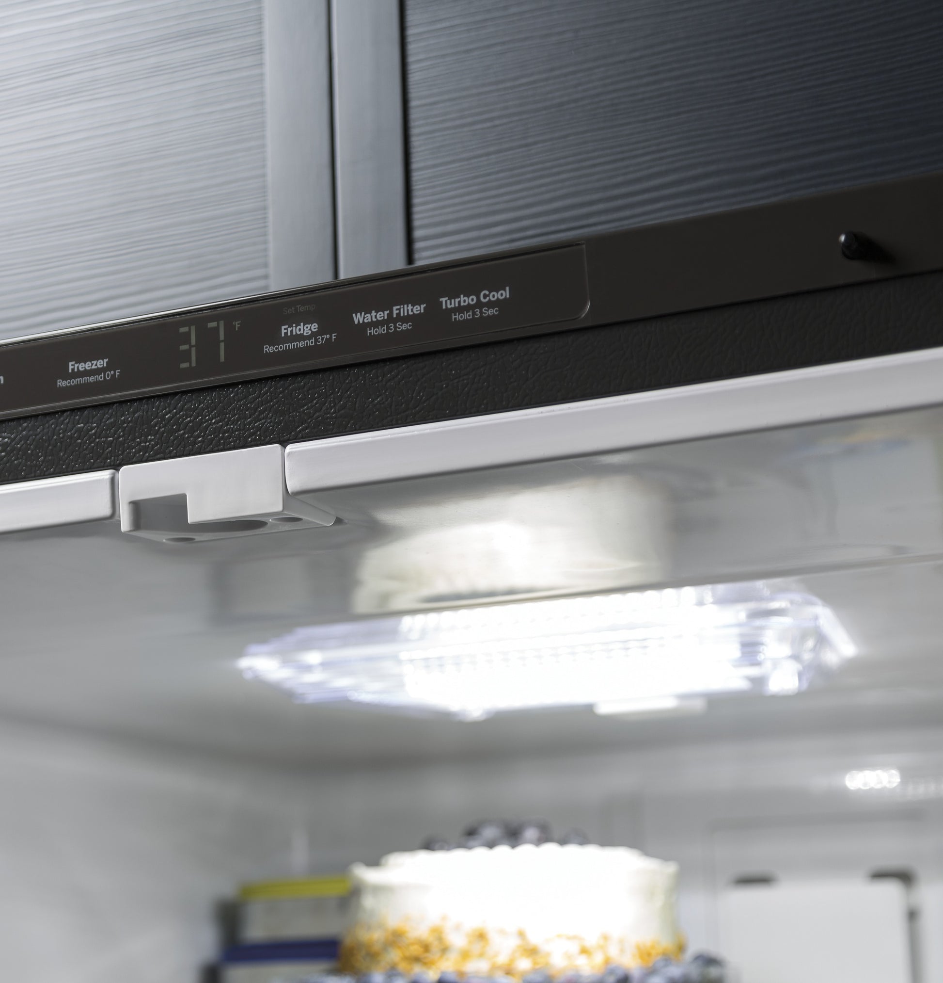 Digital control panel with temperature display and function indicators inside a black kitchen refrigerator interior