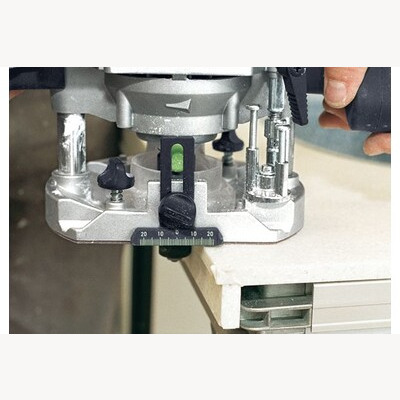 Close-up of a person adjusting a precise depth setting on a metal router for woodworking and home improvement tasks