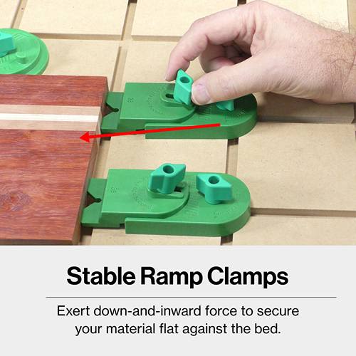 Green plastic ramp clamps with adjustable knobs securing wood flat on a table for woodworking and home improvement use